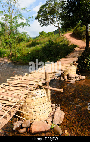 LUANG NAMTHA, Laos - Un ponte di bambù attraversando un piccolo ruscello che conduce al villaggio Lakkhamma a Luang Namtha provincia nel nord del Laos. Lakkhamma Village è stato stabilito come un progetto congiunto tra il governo del Laos e la Commissione europea. Foto Stock