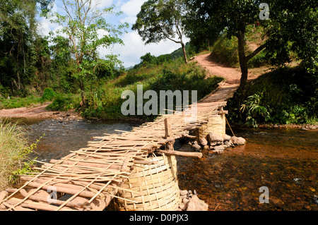 LUANG NAMTHA, Laos - Un ponte di bambù che attraversa un piccolo torrente che conduce al villaggio Lakkhamma a Luang Namtha provincia nel nord del Laos. Lakkhamma Village è stato stabilito come un progetto congiunto tra il governo del Laos e la Commissione europea. Foto Stock