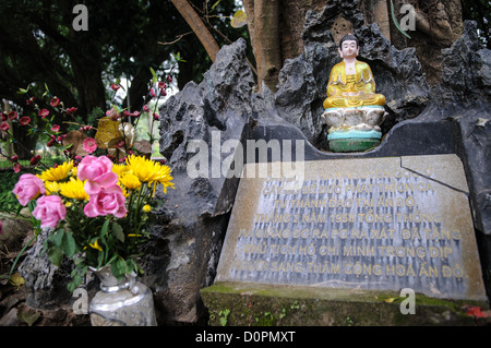 HANOI, Vietnam - Un piccolo shrone si trova in un vecchio albero storto vicino alla Pagoda One Pillar. La piccola e storica Pagoda a un pilastro si trova nel centro di un piccolo stagno vicino al Museo di ho chi Minh nel quartiere Ba Dinh di Hanoi. È uno dei templi più iconici del Vietnam e risale all'XI secolo. Foto Stock