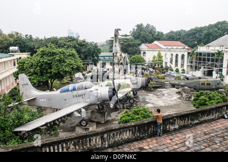 HANOI, Vietnam: Una vista dall'alto dalla piattaforma di osservazione della Torre della bandiera di Hanoi mostra una serie di attrezzature militari statunitensi catturate e abbandonate esposte nel cortile del Museo di storia militare del Vietnam. Lo spazio espositivo all'aperto alla base della torre di 33 metri presenta vari veicoli e attrezzature del periodo della guerra del Vietnam. Questa prospettiva elevata offre una vista completa della collezione di manufatti militari del museo. Foto Stock