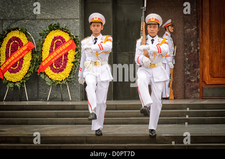 HANOI, Vietnam - due soldati si fanno strada dall'ingresso del Mausoleo di ho chi Minh come parte della cerimonia del cambio della guardia. Un grande memoriale nel centro di Hanoi circondato da Piazza Ba Dinh, il Mausoleo di ho chi Minh ospita il corpo imbalsamato dell'ex leader vietnamita e presidente fondatore ho chi Minh. Foto Stock