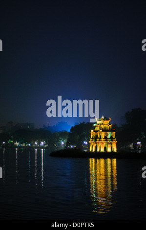 Foto di notte le luci della Torre di tartaruga (noto anche come torre di tartaruga su una piccola isola nel Lago Hoan Kiem nel centro storico di Hanoi, Vietnam. Luci della città nella luce dello sfondo di un profondo cielo blu. Copyspace nella parte superiore del telaio. Foto Stock