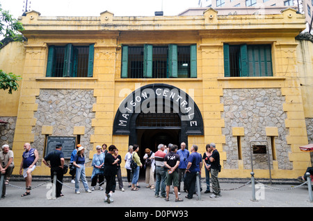 HANOI, Vietnam - turisti in piedi sul marciapiede di fronte all'ingresso principale del museo della prigione di Hoa lo. La prigione di Hoa lo, nota sarcasticamente come Hanoi Hilton durante la guerra del Vietnam, era originariamente una prigione coloniale francese per prigionieri politici e poi una prigione nordvietnamita per prigionieri di guerra. È particolarmente famosa per essere la prigione utilizzata per i piloti americani abbattuti durante la guerra del Vietnam. Foto Stock