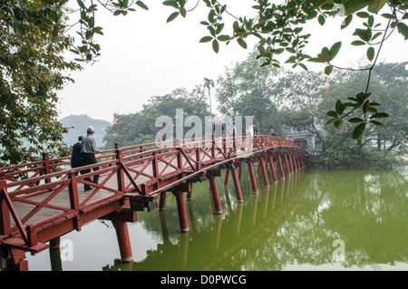 HANOI, Vietnam — il ponte Huc con i turisti. Il ponte di legno dipinto di rosso unisce la riva settentrionale del lago con l'Isola di Giada e il Tempio della montagna di Giada (Ngoc Son Temple). Foto Stock