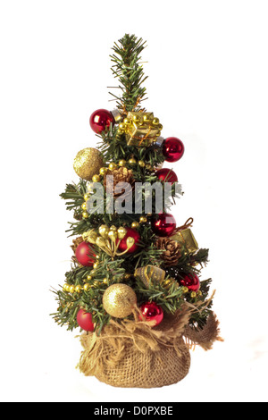 Carino piccolo albero di natale con ornamenti e presenta isolato su bianco Foto Stock