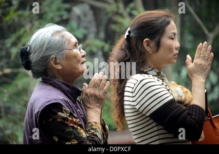 HANOI, Vietnam - due donne pregano al Tempio della montagna di Giada (Ngoc Son Temple) sul lago Hoan Kiem nel cuore del centro storico di Hanoi. Il tempio è stato fondato sulla piccola isola di Jade vicino alla riva settentrionale del lago nel XVIII secolo ed è in onore del leader militare del XIII secolo Tran Hung Dao. Foto Stock