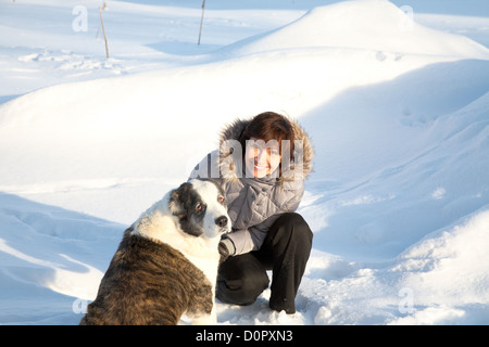 La donna gioca con un cane nel giorno di inverno Foto Stock