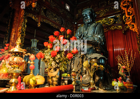 HANOI, Vietnam - un santuario buddista ornato occupa una cappella laterale all'interno della Pagoda Tran Quoc sull'isolotto dei pesci d'oro del Lago Occidentale. Gli elementi decorativi rappresentano il tradizionale stile artistico buddista vietnamita e il simbolismo religioso. Questo spazio devozionale continua a servire il suo scopo originale all'interno di uno dei templi buddisti più antichi del Vietnam. Foto Stock