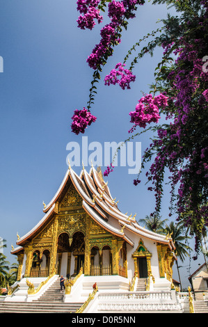 LUANG PRABANG, Laos — la facciata ornata e la linea del tetto ripida angolata di Haw Pha Bang (Cappella del Palazzo) presso il Museo del Palazzo reale di Luang Prabang, Laos. Questa elegante struttura, iniziata nel 1963, mette in mostra elementi architettonici tradizionali del Laos con i suoi intricati dettagli e il suggestivo tetto. Foto Stock