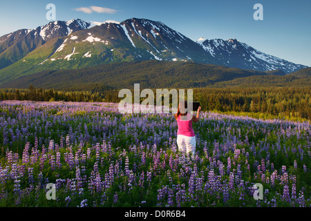 Visitatore di scattare una foto con un ipad, Chugach National Forest, Alaska. (Modello rilasciato) Foto Stock