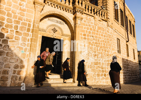 Il siriaco donne lasciando la chiesa dopo la messa. Midyat, Mardin Provincia, Turchia Foto Stock