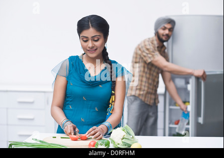 Donna tritare verdure in cucina Foto Stock