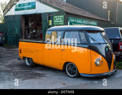 Bovey Tracey, Devon, Inghilterra. Il 29 novembre 2012. Garage rurale e il piazzale antistante con colorati Volkswagen pickup. Foto Stock