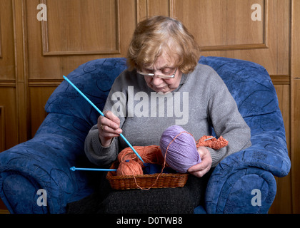 La vecchia donna si siede in una poltrona Foto Stock