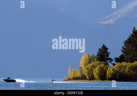 Inizio serata sci d'acqua sul lago Wanaka. Wanaka è un anno meta turistica insieme contro la incontaminata cornice alpina del Monte aspiranti National Park in Central Otago. Isola del Sud, Nuova Zelanda. Il 23 marzo 2011. Foto Stock
