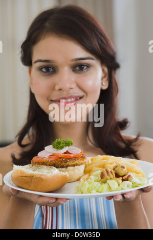 Donna che mantiene una piastra di pranzo Foto Stock