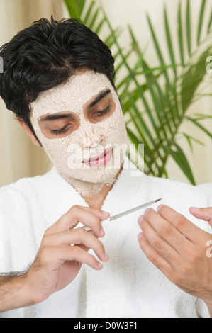 Close-up di un uomo con maschera al viso e archiviare i suoi chiodi Foto Stock