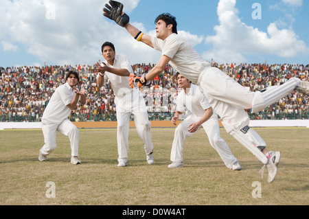 Cricket wicket keeper e fielders tenta per la cattura Foto Stock