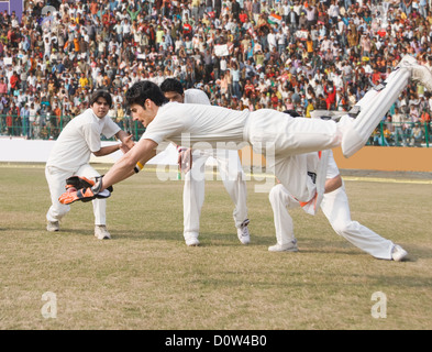 Cricket wicket keeper e fielders tenta per la cattura Foto Stock