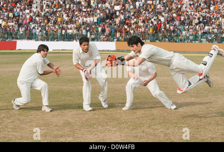 Cricket wicket keeper e fielders tenta per la cattura Foto Stock