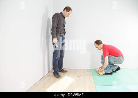 Uomo che guarda l'installazione di pavimentazione Foto Stock