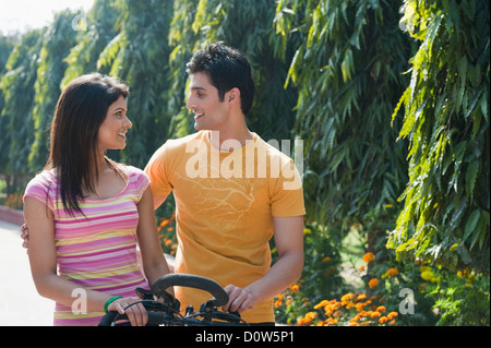 Matura in sella ad una bicicletta in un giardino Foto Stock