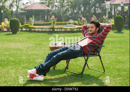 L'uomo napping in un giardino Foto Stock