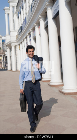 Imprenditore a piedi con una valigetta, Gurgaon, Haryana, India Foto Stock