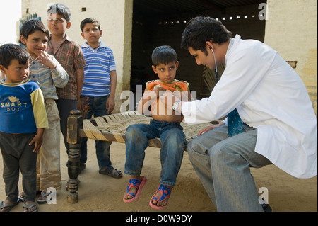 Medico esaminando un ragazzo con uno stetoscopio, Hasanpur, Haryana, India Foto Stock