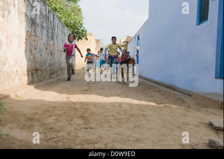 I bambini in esecuzione in una strada, Hasanpur, Haryana, India Foto Stock