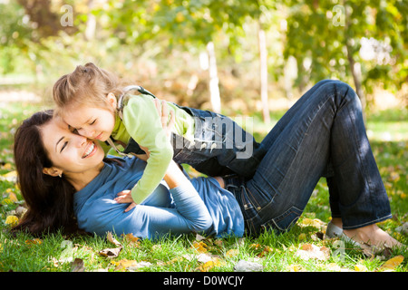 Donna con bambino divertirsi nel parco di autunno Foto Stock
