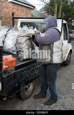 L'uomo offrendo carbone ai clienti una casa in Lancashire. Foto Stock