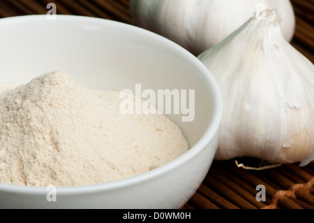 Aglio schiacciato in polvere e capi interi di aglio da vicino Foto Stock