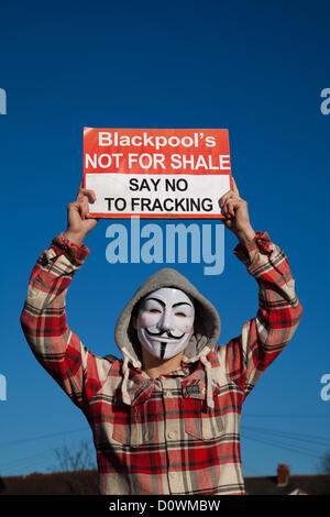 Uomo che indossa anonimo maschera facciale ; 'Guy Fawkes maschere'   manifestanti contro un REGNO UNITO 'Dash al gas' e fracking per gas di scisto, marciando per le strade di Lytham St Annes in rotta per Caudrilla del sito di perforazione Anna's Road off Case del Nord Lane, St Annes, Blackpool, Lancashire. Anti-fracking manifestanti desidera che la perforazione di stop fino a che i rischi sono completamente valutati. Foto Stock