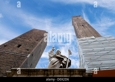 Due torri e la statua di San Petronio sotto il cielo blu a Bologna, Italia Foto Stock