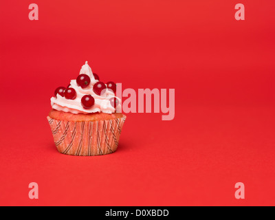 Muffin con ribes rosso su sfondo rosso Foto Stock