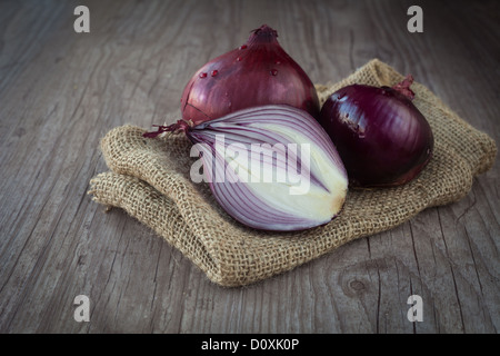 Crudo fresco cipolla rossa su uno sfondo di legno Foto Stock