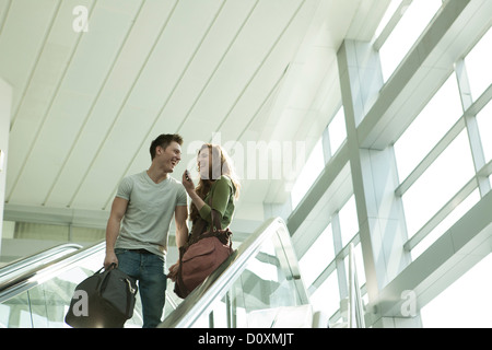 Coppia giovane che viaggiano in Escalator Foto Stock