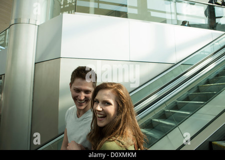 Coppia giovane che viaggiano in Escalator Foto Stock