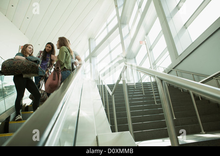 Amici che viaggiano su escalator Foto Stock