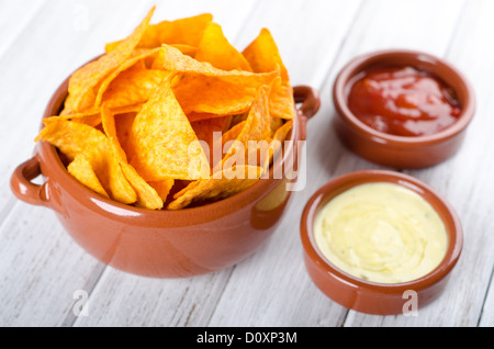 Tortilla chips con due salse differenti su un tavolo bianco Foto Stock