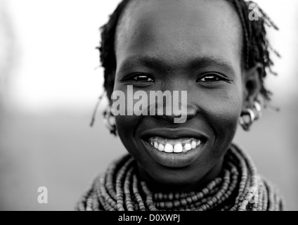 Bianco e nero ritratto di una giovane tribù Nyangatom donna con sorriso toothy, Valle dell'Omo, Kangate, Etiopia Foto Stock