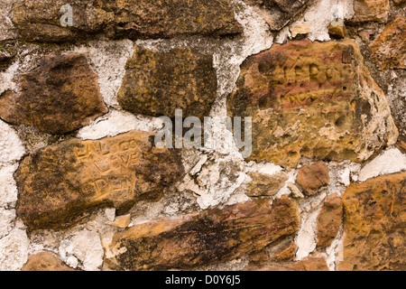 Graffiti incisi in blocchi di arenaria, all'interno del cancello principale presso la missione di San Juan Capistrano in San Antonio, Texas. Foto Stock