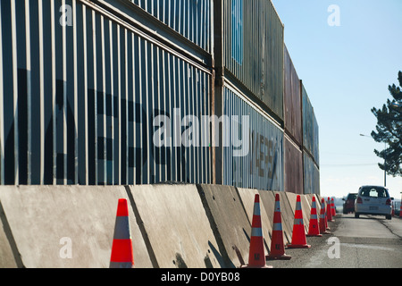 I contenitori utilizzati per proteggere la strada dalla scogliera di roccia cade dopo la Feb 2011 terremoto. Christchurch, Canterbury, Nuova Zelanda. Foto Stock