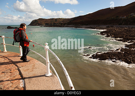 Persona in piedi sulla parete del porto guardando il mare, Bonne Nuit, Jersey costa del nord, Isole del Canale, REGNO UNITO Foto Stock