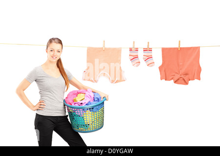 Donna sorridente tenendo un cesto per la biancheria e una linea bucato con vestiti isolati su sfondo bianco Foto Stock