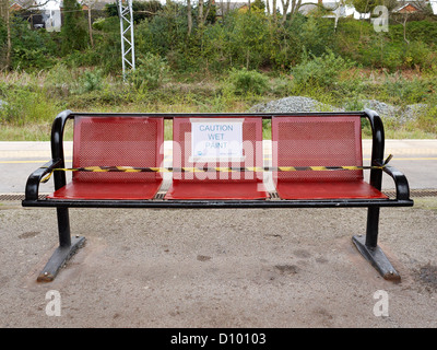 Attenzione vernice fresca di avvertimento sulla stazione ferroviaria di banco della piattaforma in Sandbach Regno Unito Foto Stock