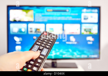 Smart tv e mano, premendo il telecomando Foto Stock