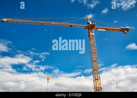 Parte del giallo della costruzione di gru a torre braccio contro il cielo blu Foto Stock