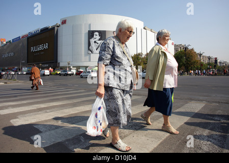 Bucarest, Romania, pedoni attraversare una strada in corrispondenza di un crosswalk Foto Stock